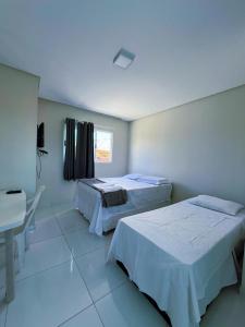ein Krankenzimmer mit zwei Betten und einem Schreibtisch in der Unterkunft ParkMar III - São José, Maragogi in São José da Coroa Grande