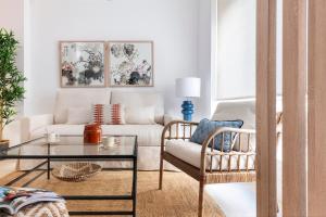 una sala de estar con un sofá y una mesa en Magno Apartments Monte Carmelo, en Sevilla