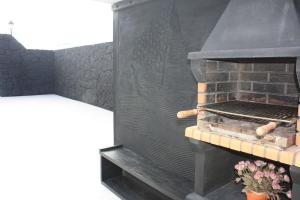 a barbecue grill with a brick wall at Villa Lanzarote Zen in Playa Blanca