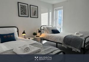 Dos camas en un dormitorio con toallas. en Shrewsbury Townhouse with 3 En-suites, en Shrewsbury