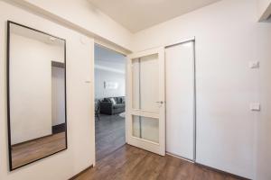 a hallway with a mirror and a living room at Forenom Serviced Apartments Helsinki Lapinlahdenkatu in Helsinki