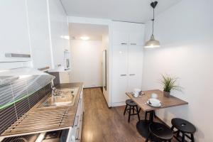 a kitchen with a sink and a table with chairs at Forenom Serviced Apartments Helsinki Lapinlahdenkatu in Helsinki
