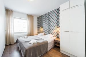a bedroom with a bed with two towels on it at Forenom Serviced Apartments Helsinki Lapinlahdenkatu in Helsinki