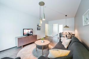 a living room with a couch and a tv at Forenom Serviced Apartments Helsinki Lapinlahdenkatu in Helsinki
