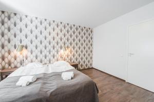 a bedroom with a bed with two white towels at Forenom Serviced Apartments Helsinki Lapinlahdenkatu in Helsinki