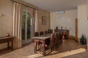 a dining room with a wooden table and chairs at Villa Iris in Benalup Casas Viejas