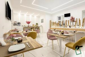 a restaurant with wooden tables and pink chairs at Hotiday Room Collection - Napoli Sant'Arcangelo in Naples