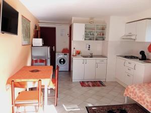 a kitchen with white cabinets and a table and a sink at Apartma Gorjan in Tolmin
