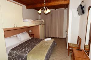 a bedroom with a bed and a table and a desk at CASA MAIRA IN CENTRO A SATURNIA in Saturnia