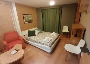 a bedroom with a bed and a chair and a table at Estudio de diseño con parking en el centro in Huesca