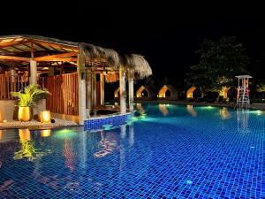a swimming pool at night with a resort at Mactan Newtown staycation near airport with pool access in Punta Engaño