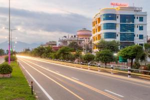 una strada vuota in una città con edifici di The SR Hotel a Jogīkuti