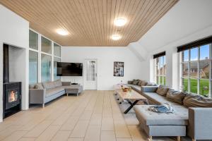 a living room with a couch and a fireplace at Large Holiday Home For 20 People With Large Pool, Hot Tub For 7 People And Activity Room in Ringkøbing