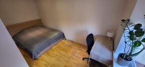 een kleine kamer met een bed en een bureau bij Cosy Park Apartment, Free parking, Self-Check-In in Klaipėda