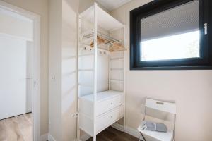 a walk in closet with white shelves and a window at Oesterpad 56 - Het Oude Nieuwland Ouddorp in Ouddorp