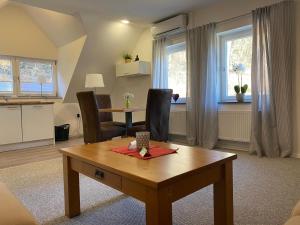 a living room with a table and a kitchen at Ferienwohnung Sommerlinde in Altleiningen