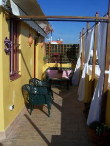 Un balcón con sillas y mesas en un edificio en Apartamento Calle Goles, en Sevilla