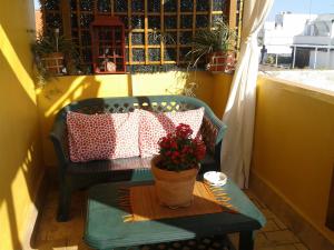 un porche con un banco con una maceta. en Apartamento Calle Goles, en Sevilla