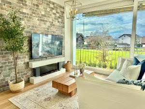 a living room with a fireplace and a tv at FLAIR Apartments Vorarlberg - Stilvolles Wohnen nahe Bodensee & Alpen - Küche, Balkon & Gratis Parkplatz in Bregenz