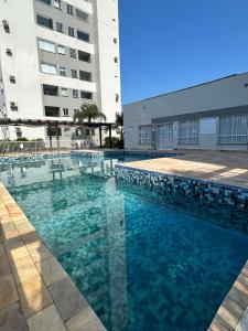a large swimming pool in front of a building at Residencial Órion Condomínio Piscina 250m Praia in Piçarras