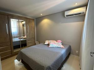 a small bedroom with a bed and a mirror at Residencial Órion Condomínio Piscina 250m Praia in Piçarras +28 photos