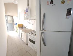 a kitchen with a white refrigerator and a stove at Apart More in Villa Mercedes