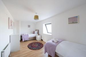 a white bedroom with a bed and a window at Woodside Barn Stunning 7 bed Barn conversion in Newmachar