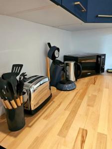 a kitchen with a toaster on a wooden floor at La Perle Bleue in Compiègne