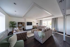 a large living room with couches and a tv at Woodside Barn Stunning 7 bed Barn conversion in Newmachar