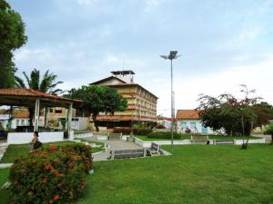 a park with a building in the background with flowers at Apartamento Rio Preguiças in Barreirinhas