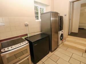 Una cocina con refrigerador de acero inoxidable y estufa. en Norchard Farm House, en Tenby 45 fotos más