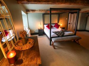 1 dormitorio con cama con dosel y mesa en Norchard Farm House, en Tenby
