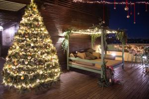 a christmas tree on a deck with a couch at La Griffe Hotel Roma in Rome