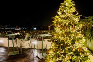 a christmas tree on a deck with tables and chairs at La Griffe Hotel Roma in Rome