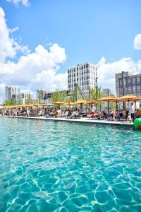 a pool of water with people sitting in chairs at Nyvky Like Home - Файна Таун з басейном - Кв 398 in Kyiv