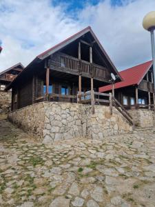 uma grande casa de madeira com uma parede de pedra em Chalé 40 - Penhas da Saúde em Penhas da Saúde