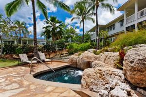 a pool with a waterfall and two chairs in a yard at Coconut Plantation 1194-3 in Kapolei