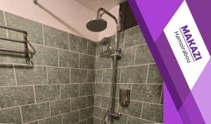 a shower with a shower head in a bathroom at MAKAZI Hamoirabou in Tsingoni