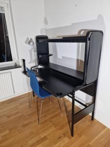 a black desk with a blue chair in a room at En nyrenoverad lägenhet med 2 sovrum in Gothenburg