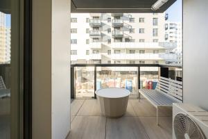 einen Balkon mit einem Tisch und ein großes Gebäude in der Unterkunft Ironcrest Studio - Cortina in Voluntari