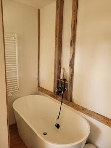 a white bath tub in a bathroom with a mirror at wunderschönes Obergeschoss in Bahnhofsnähe in Cottbus +9 photos
