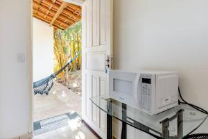 a microwave sitting on a glass table next to a door at Pousada Luna in Socorro
