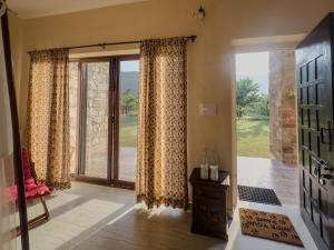 a living room with a sliding glass door at Chokhiwadi Forest Retreat in Dogeta