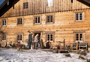a group of people standing outside of a wooden building at Auszeit-Biohof Neihausmo in Böbing