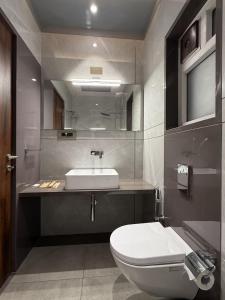 a bathroom with a white toilet and a sink at Golden Heritage Dapoli in Dapoli +55 photos