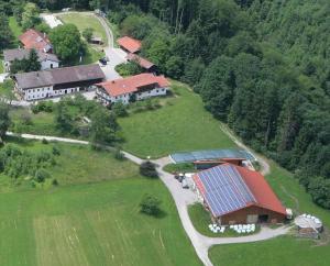 eine Luftansicht eines Hauses mit Sonnenkollektoren auf einem Feld in der Unterkunft Schusterhof Urlaub auf dem Bauernhof in Bernau am Chiemsee