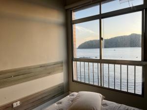 a bedroom with a window with a view of the water at apartamento sao vicente vista mar pe na areia in São Vicente