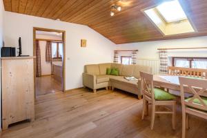 ein Wohnzimmer mit Tisch und Couch in der Unterkunft Schusterhof Urlaub auf dem Bauernhof in Bernau am Chiemsee