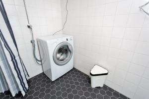 a washing machine in a bathroom with a toilet at Forenom Serviced Apartments Helsinki Kruununhaka in Helsinki