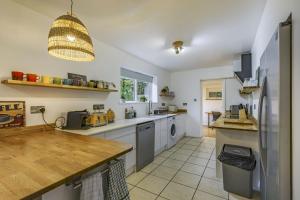a kitchen with a sink and a refrigerator at The Laurels - Wifi, Parking, 4 Bedrooms, Gatwick in Crawley